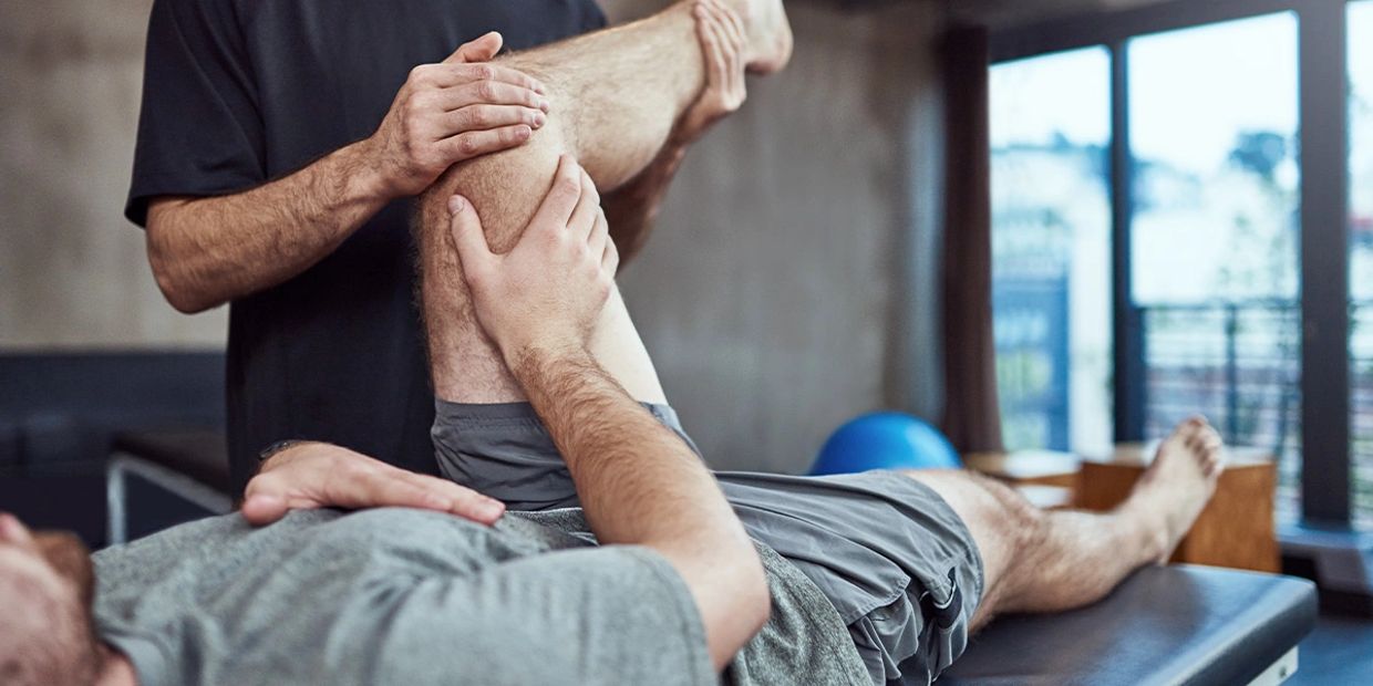 Massage therapist stretching out a clients leg