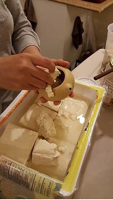 Adding tofu to a teapot.