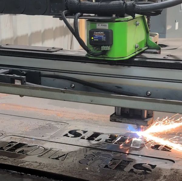 A CNC machine cutting metal with sparks flying.