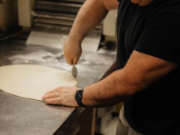 Rolling pizza dough.