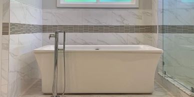 Modern bathroom renovation with custom tile,  frameless shower and free-standing tub