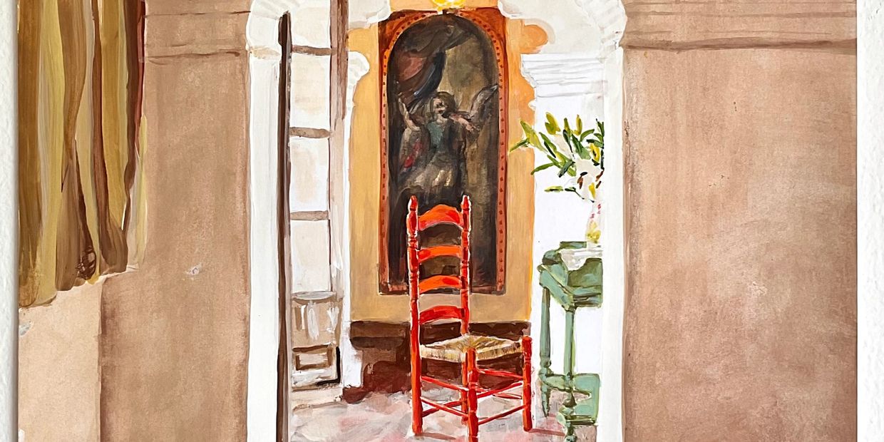 Cozy interior with a red chair and religious painting in a warm-toned room.