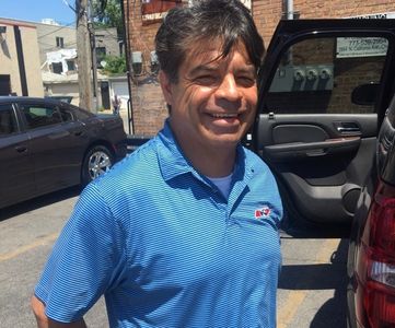 property manager smiling next to a car