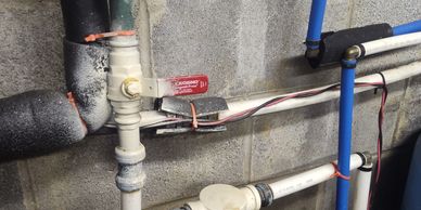 Industrial pipes and valves on a concrete wall.