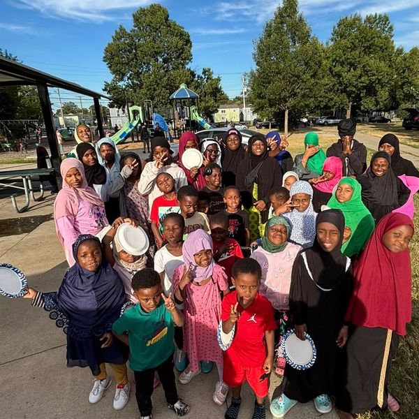 Group of children at a park holding plates.