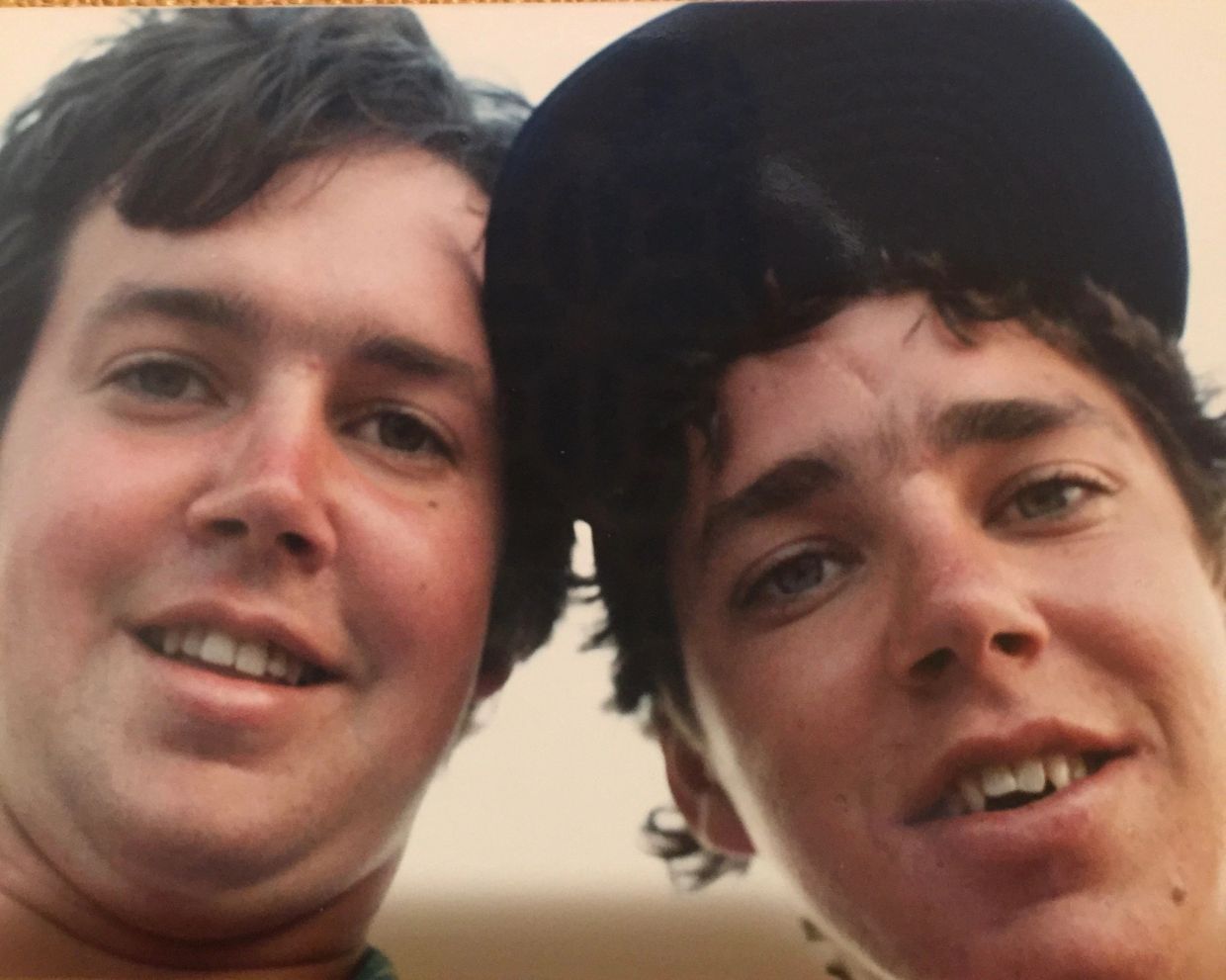Two young men smiling close to the camera.