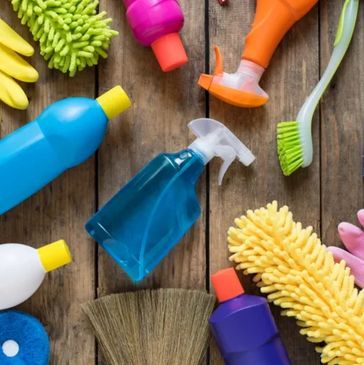 House cleaning tools laid out on wood floor.
