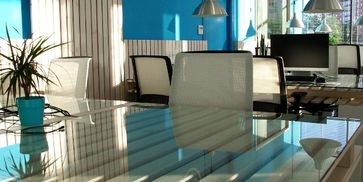 Teal and white small business office setup with tables and chairs