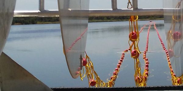 A three strand entanglement net streaming off a powered storage reel.