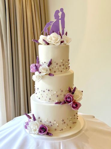 Fondant 3 tier wedding cake with lilac sugar roses and white and lilac pearls 