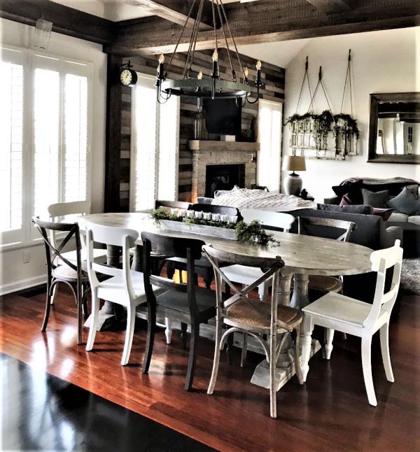 Rustic dining area with mixed chairs around a wooden table.