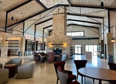 Spacious, modern lounge with stone fireplace and comfortable seating.