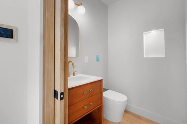 Custom stand alone vanity in powder room with custom niche and heated toilet with bidet