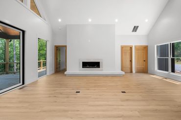 Open concept great room with custom built fireplace box and oversized windows and floor outlets