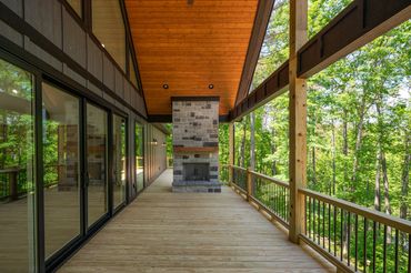 Custom outside fireplace with stained tongue & groove and mantel, oversized sliding glass door