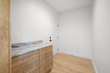 Large pantry space with custom cabinet with granite countertop and LVP flooring