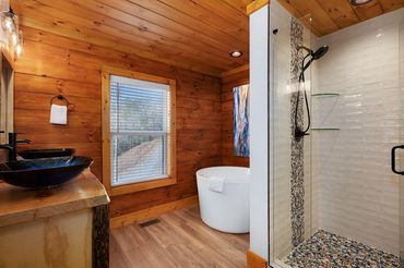 Stained shiplap and tongue & groove with a double sink vanity and custom tile shower with waterfall