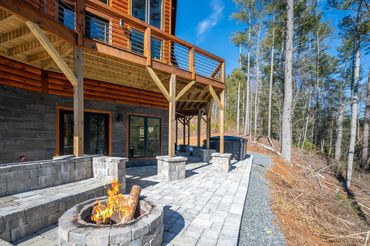Outside look at the imported custom exterior wall tile and patio stone with stone bench and fire pit