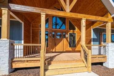 Front porch with stained tongue & groove ceiling siding & front door and huge trapezoid windows