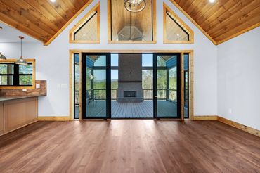 Large back full glass sliding door with large trapezoid windows above and stained tongue & groove