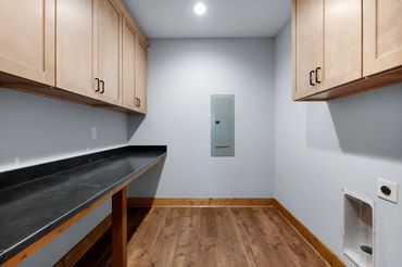 Big laundry room with wall cabinets and granite shelf