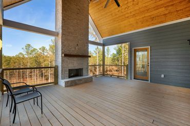 Large covered porched with vaulted tongue & groove ceiling and white stone covered fireplace