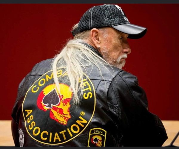 Man in a Combat Vets Association leather jacket and cap.
