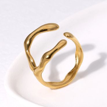 Abstract gold ring with an organic, fluid design on a white surface.