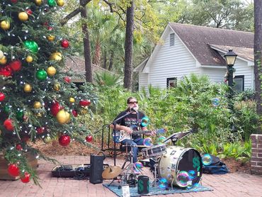 Photo of Urock Scott performing at the Pawleys Island Christmas Market in South Carolina on a warm D