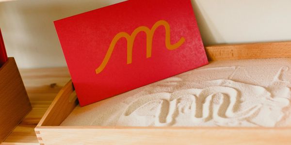 Letter M of the alphabet writing on the sand