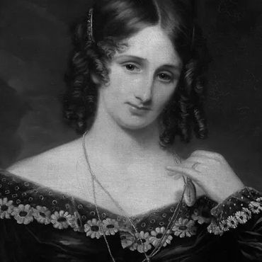 Portrait of a woman with curled hair in a dark dress with lace details.