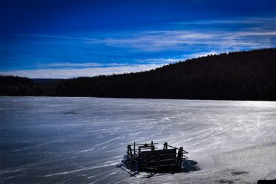 Iced over Spruce Knob Lake with beautiful blue sky in the background