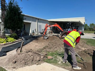Lawson Landscaping crew grading a Holmwood backyard with a mini excavator for drainage