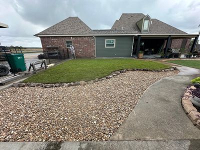 Finished Holmwood backyard with fresh sod and a river-rock bed by Lawson Landscaping