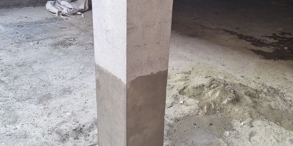 Concrete pillar with fresh cement coating at the bottom.