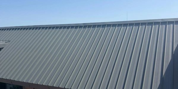 Gray metal roof under clear blue sky.