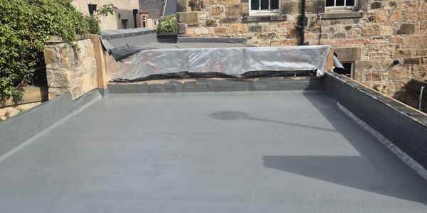 Flat rooftop with a tarp-covered section and stone walls.