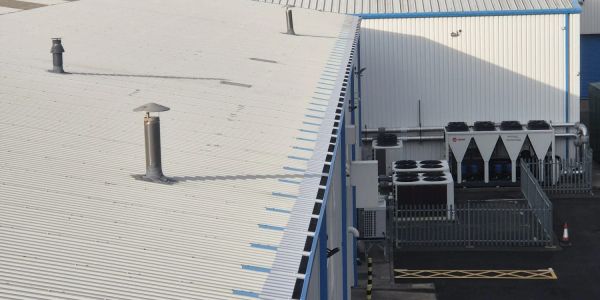Industrial rooftop with ventilation pipes and cooling units.