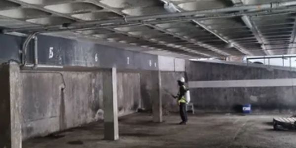 Person inspecting parking garage walls.