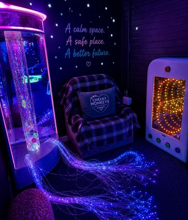 Calm sensory room with colorful lights and cozy seating.