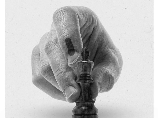 Hand holding a chess king piece with inked finger, urging India to be a game-changer.