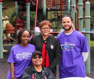 Four people posing at a playground, two wearing event t-shirts.