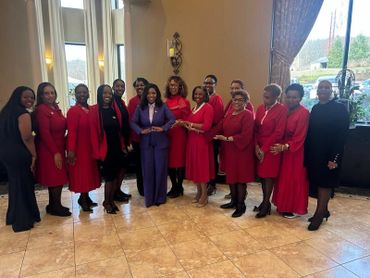 Group of women dressed in coordinated red and black outfits posing indoors.