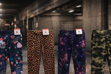 Four colorful patterned leggings displayed in a subway station.