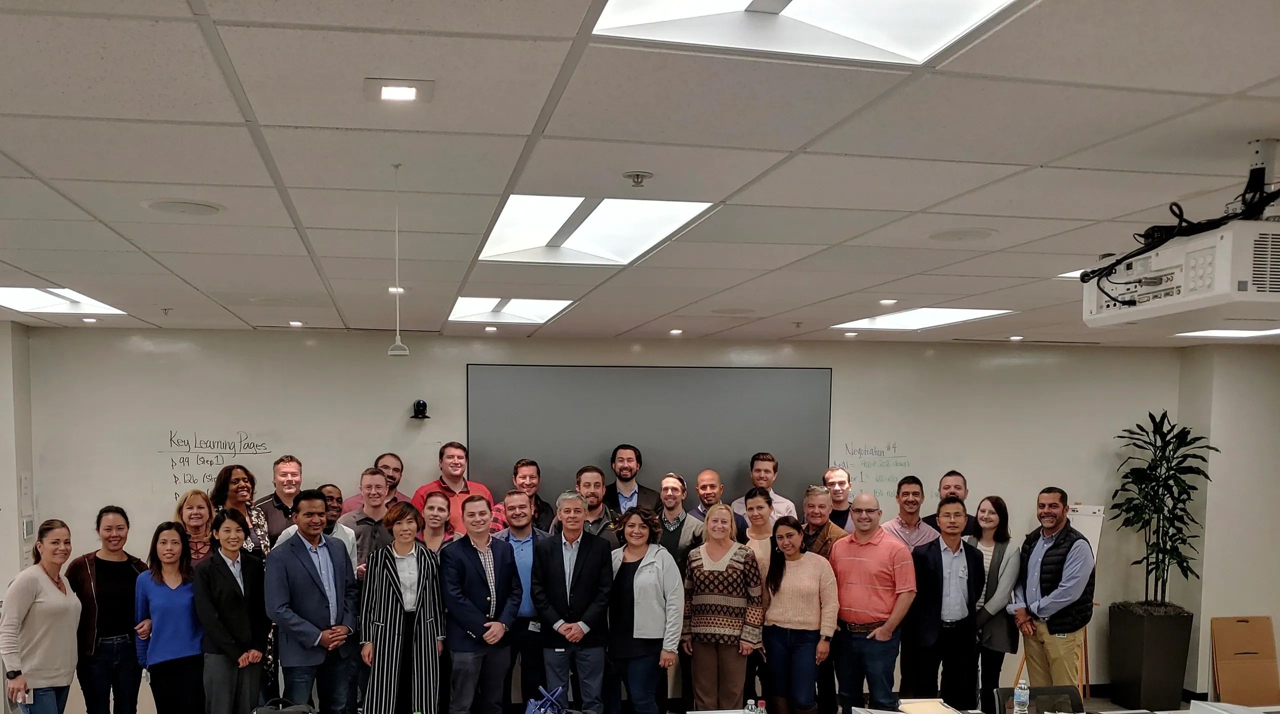 A large group of professionals posing for a photo in a conference room.