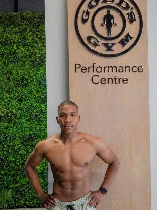 Muscular man posing shirtless at Gold's Gym Performance Centre.