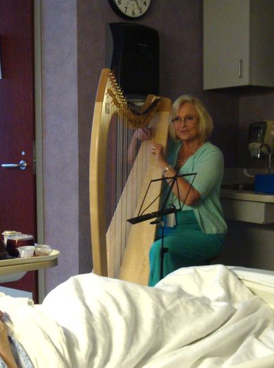 Certified Music Practitioner playing Live Therapeutic Music on a harp in a hospital room
