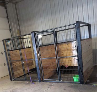 Two large metal and wood animal enclosures inside a warehouse.