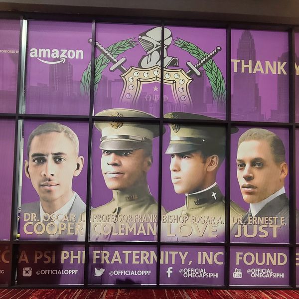 Portraits of four founders of Omega Psi Phi Fraternity with purple background and Amazon sponsorship.