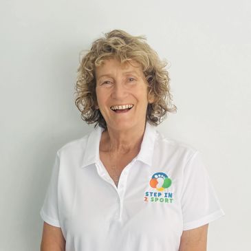 Smiling woman in a white polo with Step In Sport logo.